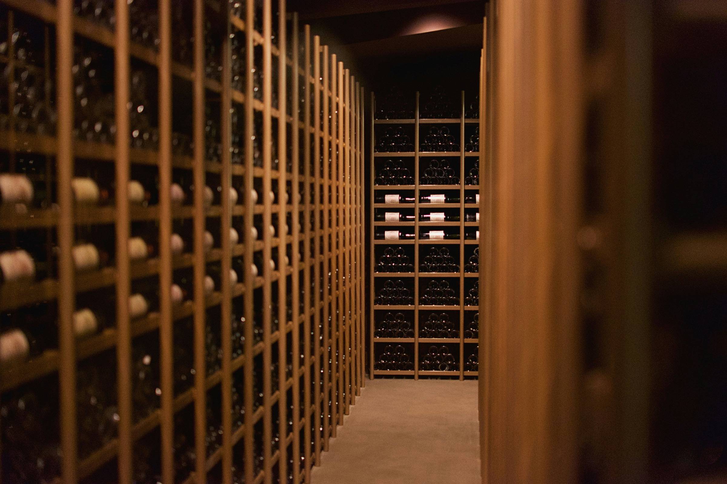 Walk-in wine room lined floor to ceiling with individual-bottle wood racking